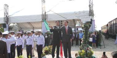 アーコム運輸大臣（右）が鐘を鳴らし、国交省の志村鉄道局次長 が手信号の旗を振った