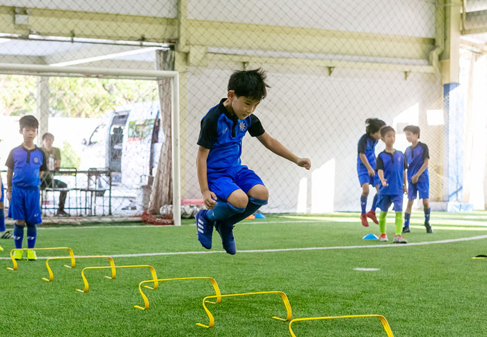 キッズクラスは、サッカーのテクニックだけでなく体の基本的な動かし方など、運動能力の向上に重きを置いたメニューを設定。U8クラスは、ドリブル・パス・シュートといったサッカーの基本的な技術に焦点を絞ったメニューを、U10・U12はそれらを発展させた練習内容となっています。