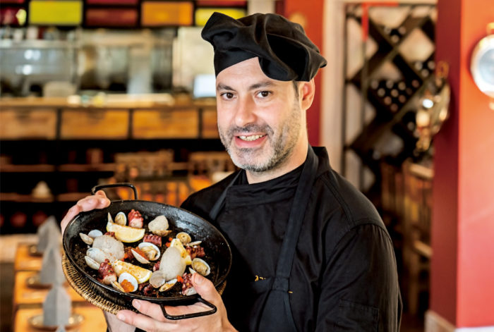 当店で一番人気のイカスミのパエリアです。お米の黒さに驚かれる方もいらっしゃいますが、魚介の旨みと特製スープをたっぷりと吸っパエリアは香ばしく、繊細かつ奥行きのある味わいが特徴です。肉厚なタコや日本産のイクラも食感と彩りを添えます。自家製のサングリアやこだわりのスペイン産ワインと共にぜひご賞味あれ!